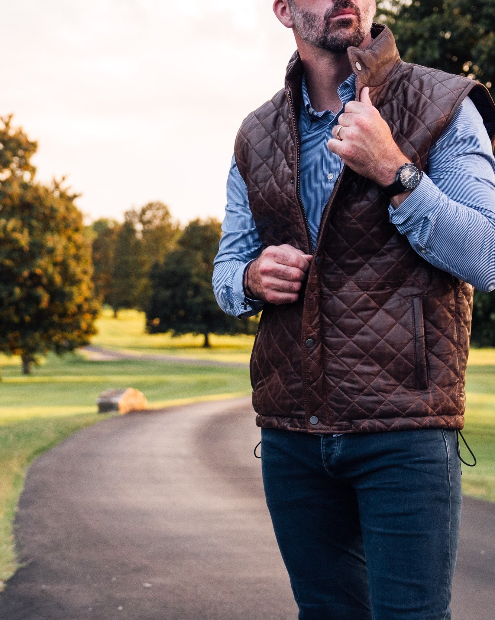 Quilted leather vest in rich mahogany brown, featuring a zippered chest pocket and high neck.