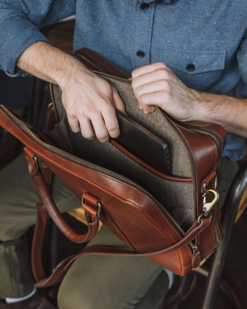 High-quality tan leather briefcase with spacious interior, suitable for laptops and documents.