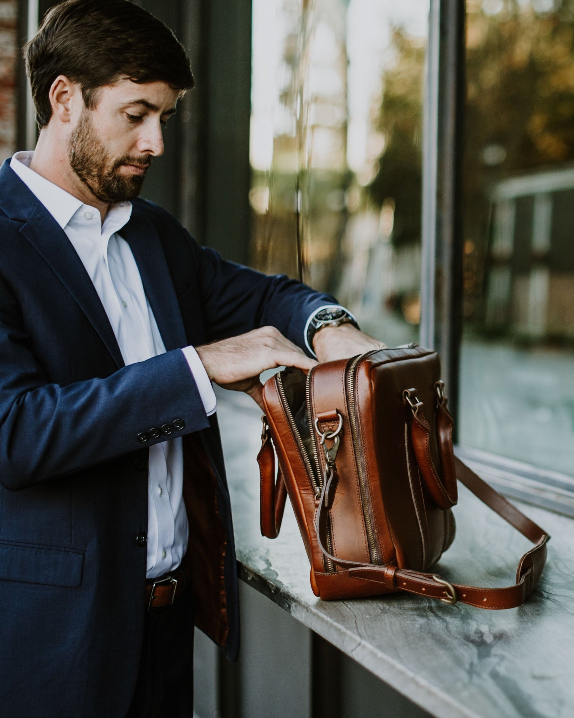 Artisan-crafted leather briefcase in warm tan, equipped with sturdy handles and detachable shoulder strap.