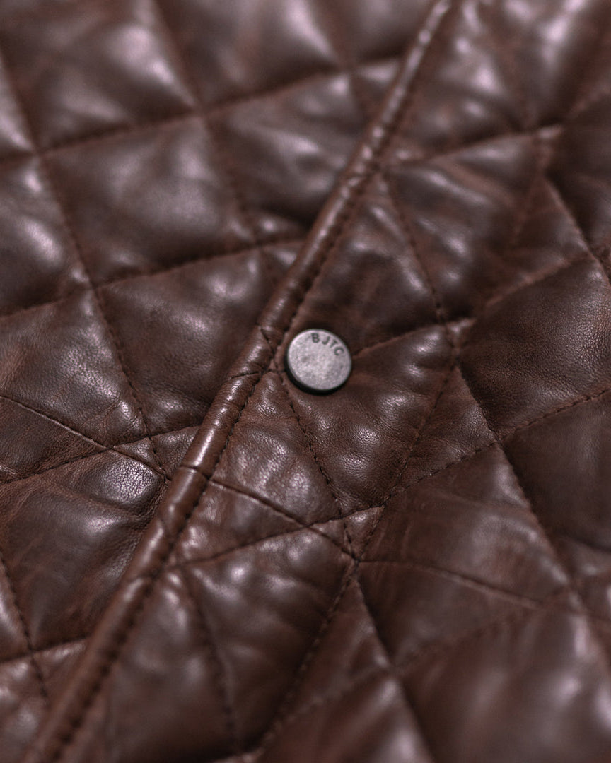 Classic mahogany brown quilted leather vest with a modern design, including practical pockets and high neck.