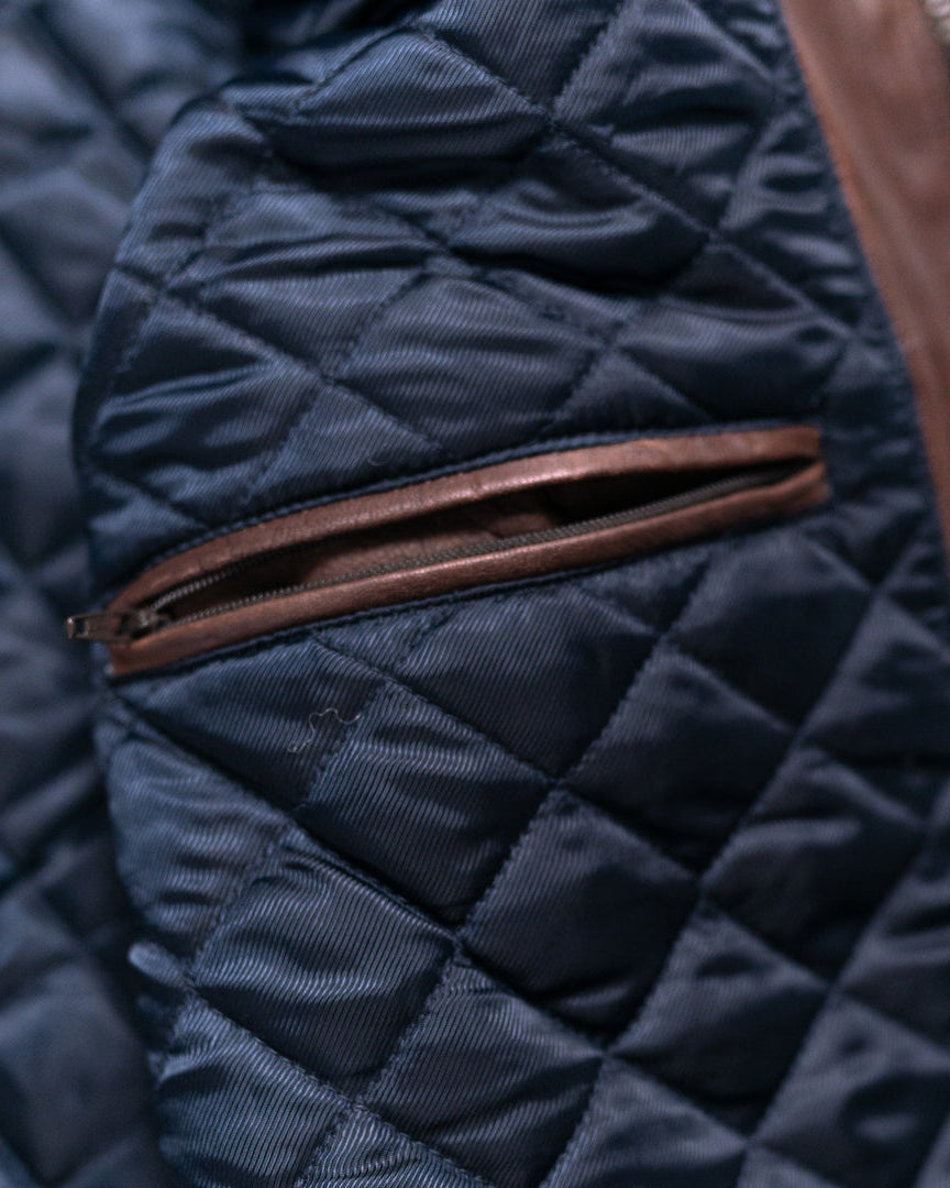 Versatile quilted leather vest in a deep mahogany hue, featuring a high collar and snap closures.
