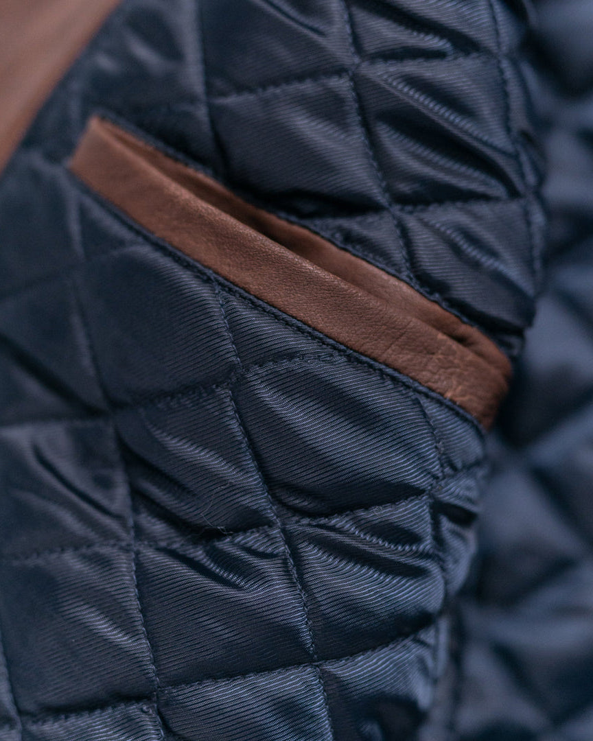 Sophisticated brown quilted leather vest with a high-neck collar and snap-button front.