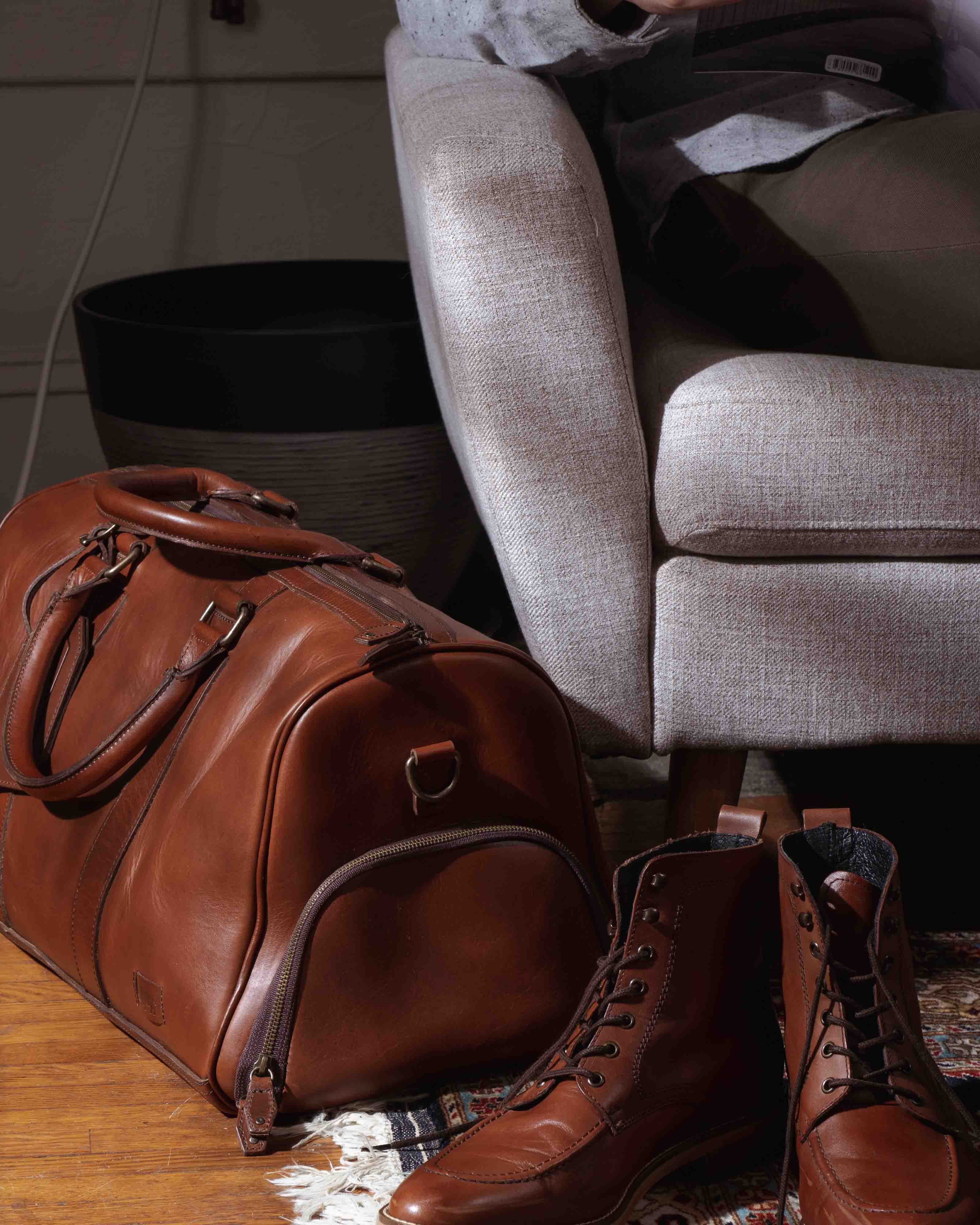 Designer leather travel duffle in warm tan, perfect for weekends, with comfortable straps and sleek design.