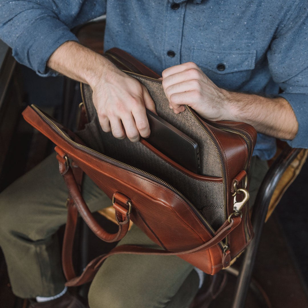 High-quality tan leather briefcase with spacious interior, suitable for laptops and documents.